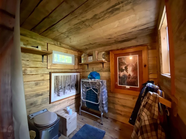 interior space with lofted ceiling, light hardwood / wood-style flooring, wooden walls, and wooden ceiling