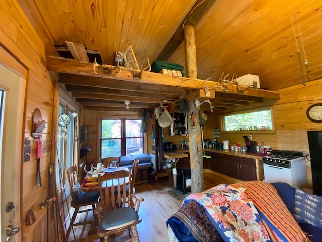 kitchen featuring wood ceiling, white gas range oven, hardwood / wood-style floors, and wooden walls
