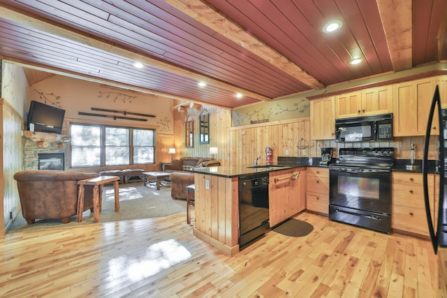 kitchen with a fireplace, black appliances, light hardwood / wood-style floors, kitchen peninsula, and light brown cabinets