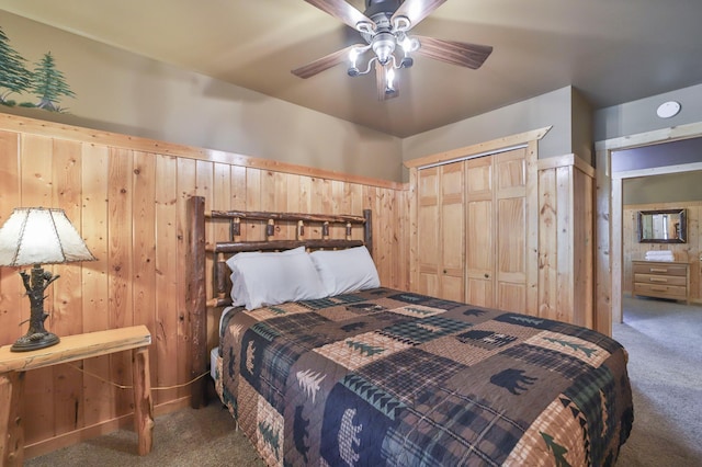 bedroom with carpet flooring, ceiling fan, and wooden walls