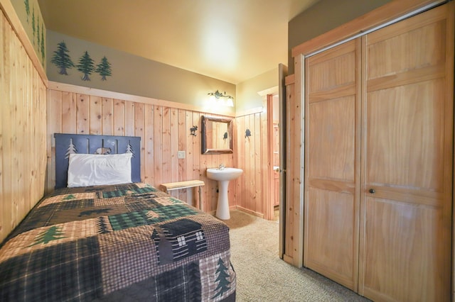 carpeted bedroom featuring wood walls