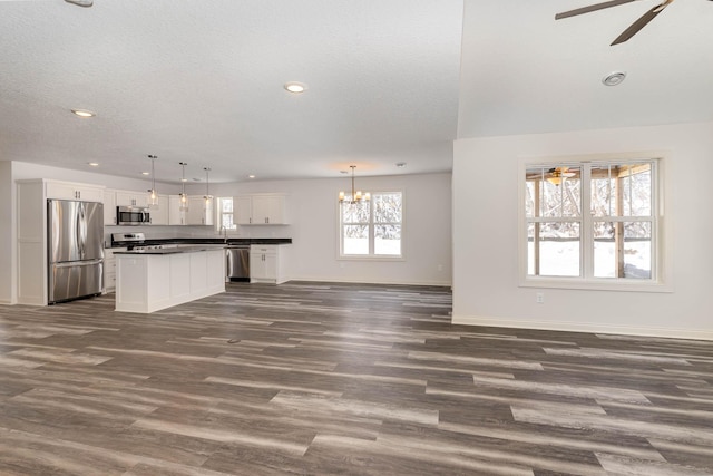 kitchen with pendant lighting, dark hardwood / wood-style floors, white cabinets, and appliances with stainless steel finishes