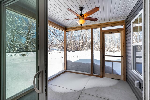 unfurnished sunroom featuring wooden ceiling and ceiling fan