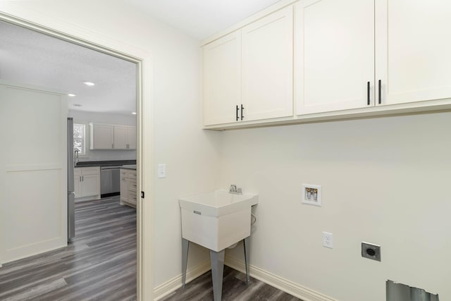 laundry area with hookup for an electric dryer, a textured ceiling, cabinets, dark hardwood / wood-style floors, and hookup for a washing machine