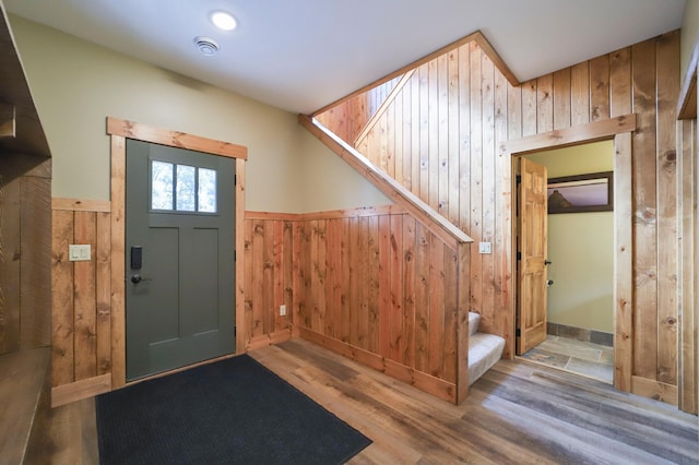 foyer entrance featuring wood walls and light hardwood / wood-style floors