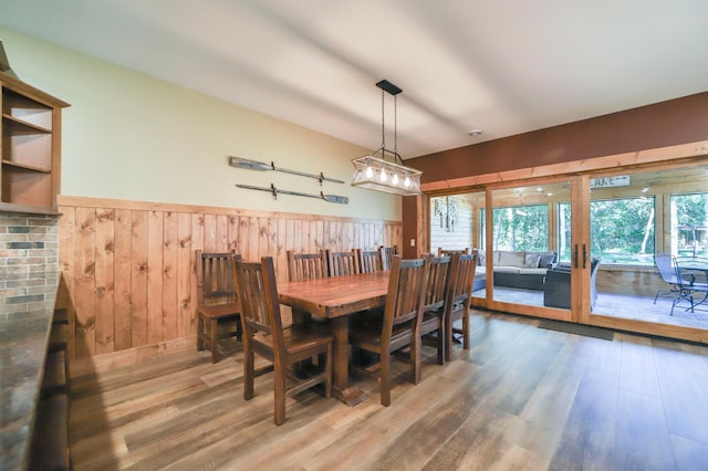 dining room featuring wood walls and wood-type flooring