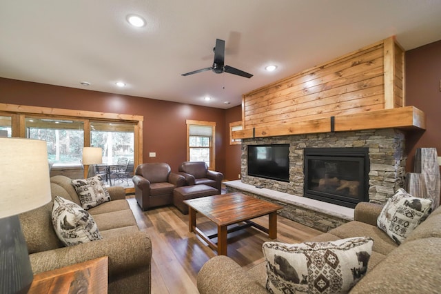 living room with a wealth of natural light, ceiling fan, wood-type flooring, and a fireplace