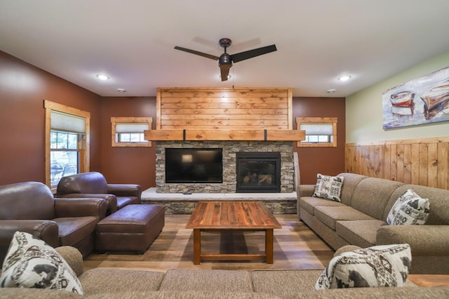 living room with ceiling fan, a fireplace, and wood-type flooring