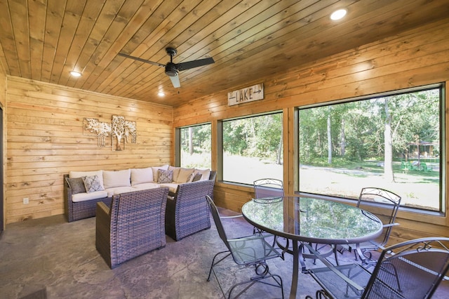 dining space featuring ceiling fan, wooden walls, and wooden ceiling