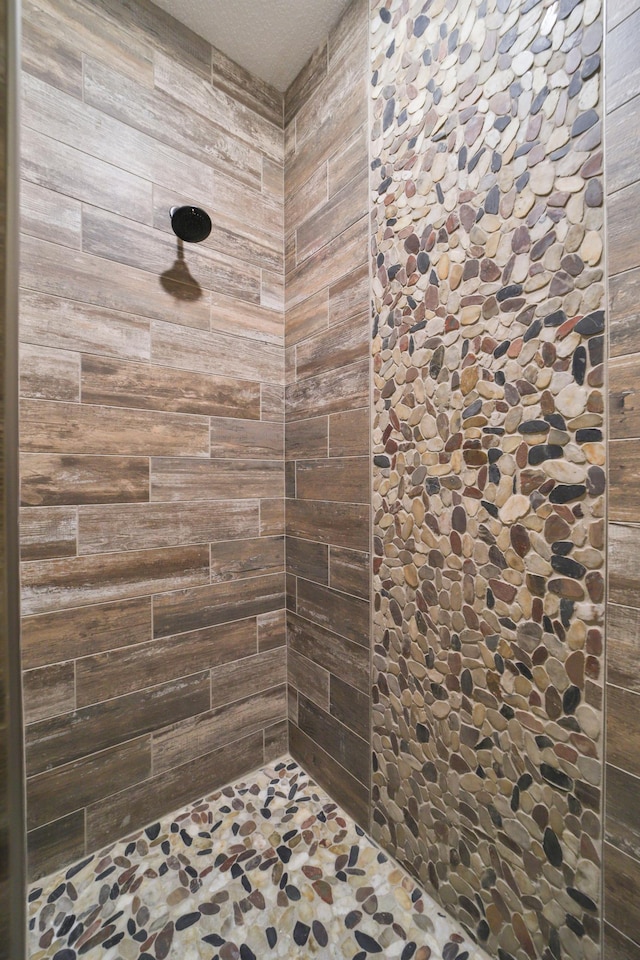 full bathroom featuring wooden walls and tiled shower