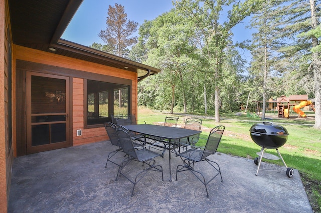 view of patio with grilling area, outdoor dining area, and a playground