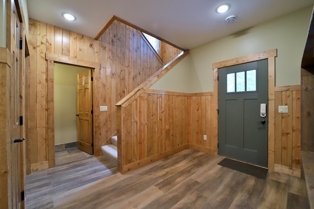 entryway featuring dark hardwood / wood-style floors and wooden walls