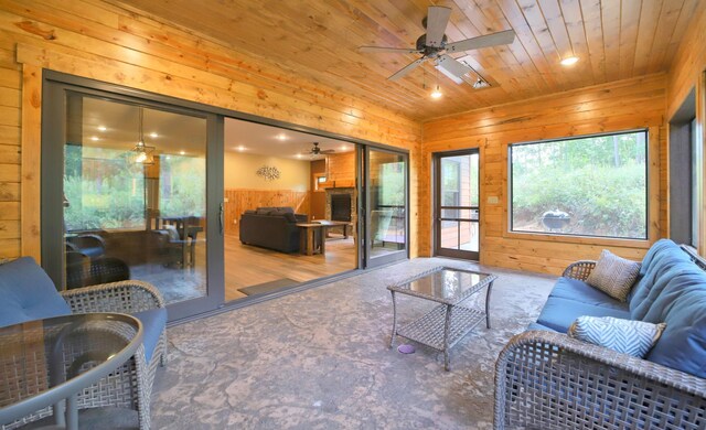 living room with wood ceiling, ceiling fan, wood walls, and wood-type flooring