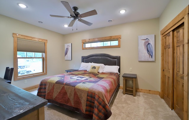 bedroom with light carpet, ceiling fan, and a closet