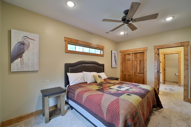 bedroom featuring light carpet, ceiling fan, and a closet