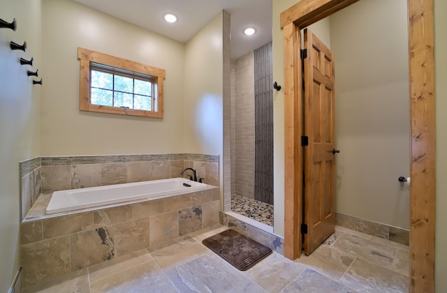 bathroom featuring separate shower and tub