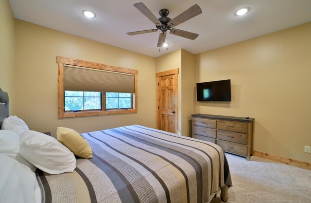 bedroom with a closet, ceiling fan, and light colored carpet