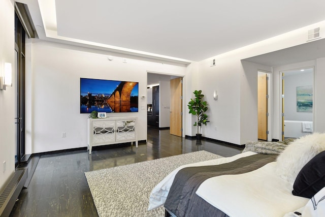 bedroom with connected bathroom and dark hardwood / wood-style floors