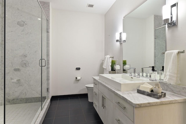 bathroom featuring tile patterned flooring, vanity, toilet, and walk in shower