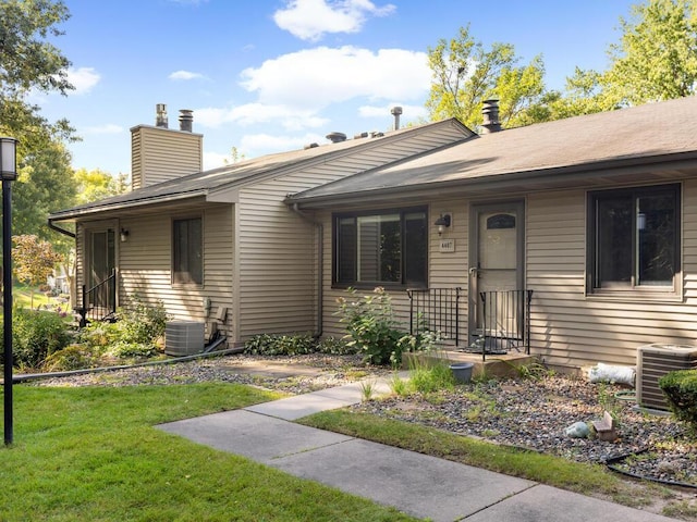 view of front of property with central AC unit and a front lawn