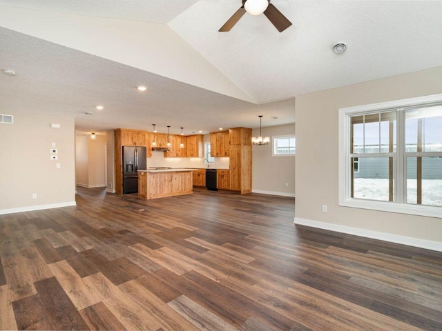 unfurnished living room with a textured ceiling, sink, ceiling fan with notable chandelier, vaulted ceiling, and dark hardwood / wood-style flooring