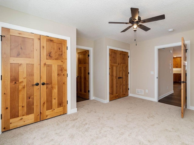 unfurnished bedroom featuring carpet, ceiling fan, and a textured ceiling