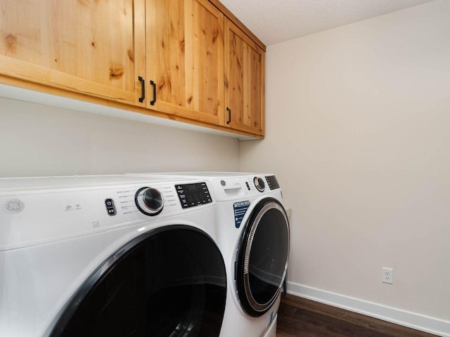 laundry room featuring a textured ceiling, cabinets, dark hardwood / wood-style floors, and washing machine and dryer