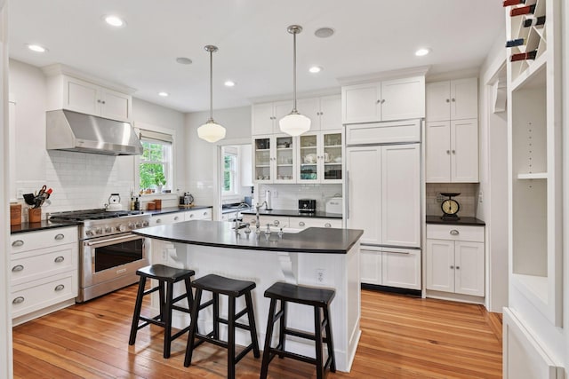 20390 Linwood Rd, Deephaven, MN 55331 - kitchen featuring high quality appliances, wall chimney exhaust hood, dark countertops, decorative backsplash, and recessed lighting
