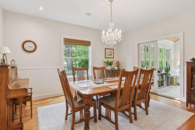 20390 Linwood Rd, Deephaven, MN 55331 - dining area with light wood-type flooring, wainscoting, and a chandelier