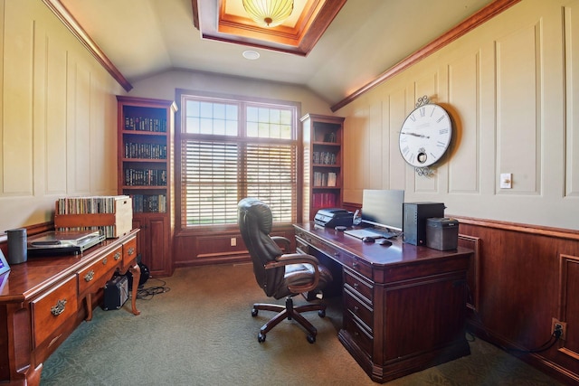 carpeted home office with lofted ceiling, crown molding, and wood walls