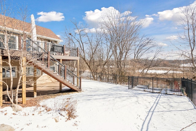 yard covered in snow featuring a wooden deck