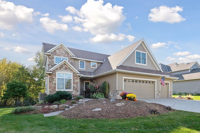 craftsman inspired home with a front lawn, fence, a garage, stone siding, and driveway