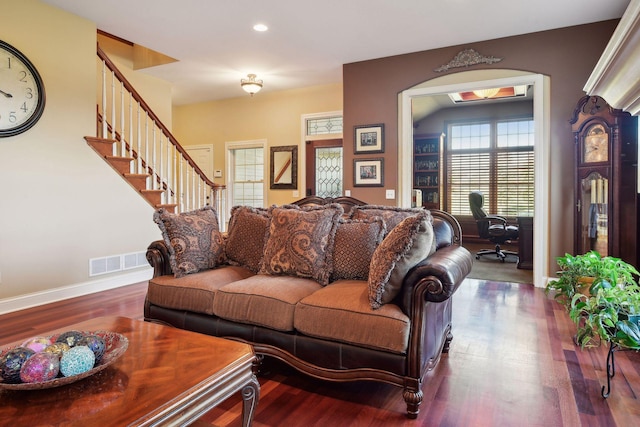 living room featuring stairway, wood finished floors, visible vents, and baseboards