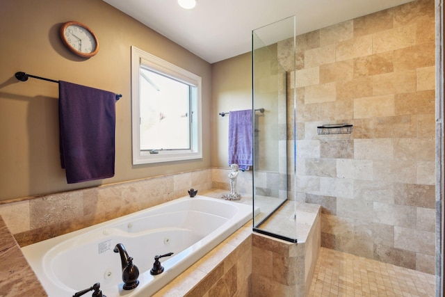 bathroom featuring a tub with jets and a tile shower