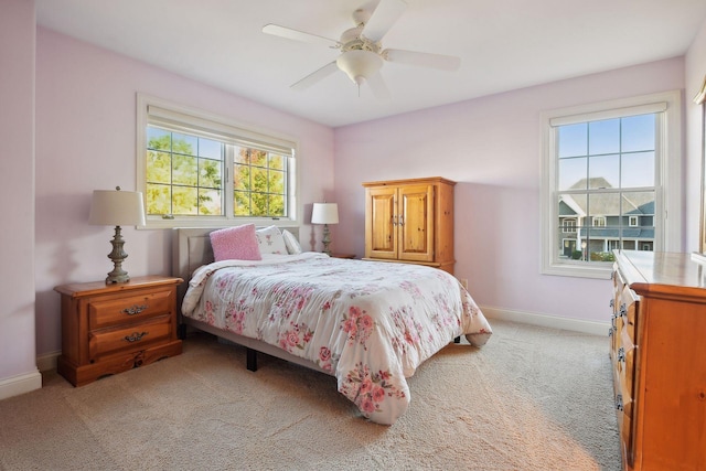 bedroom featuring baseboards, light carpet, and a ceiling fan