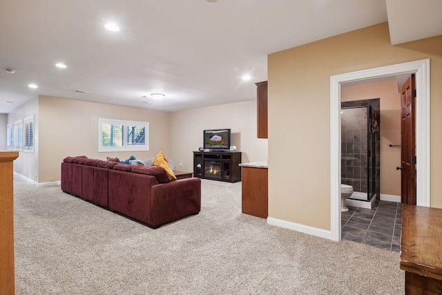 carpeted living room featuring recessed lighting, baseboards, and a glass covered fireplace