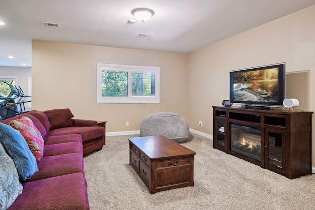 living room with plenty of natural light, visible vents, and light carpet