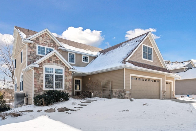 view of front of house featuring cooling unit, stone siding, and an attached garage