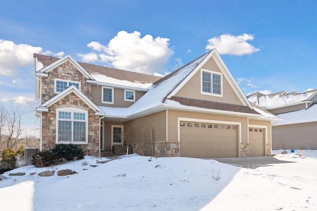 view of front facade with central air condition unit, an attached garage, and stone siding