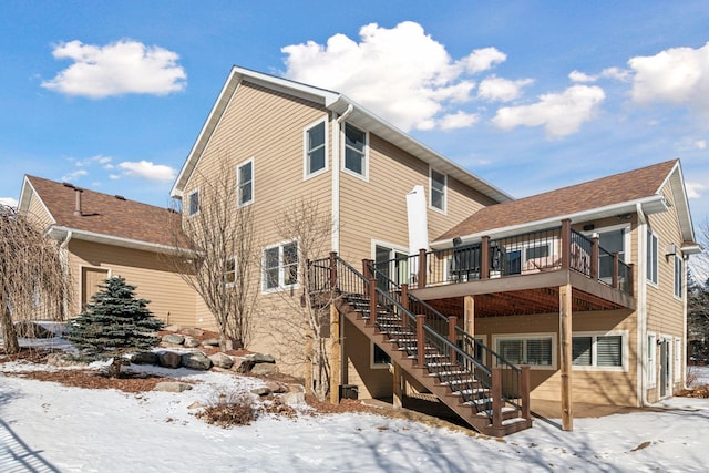 snow covered property featuring stairs and a wooden deck