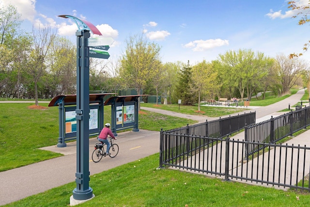 surrounding community with fence and a lawn