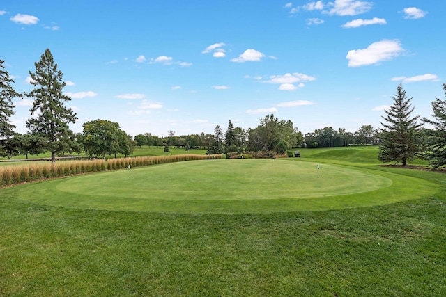 surrounding community featuring golf course view and a yard