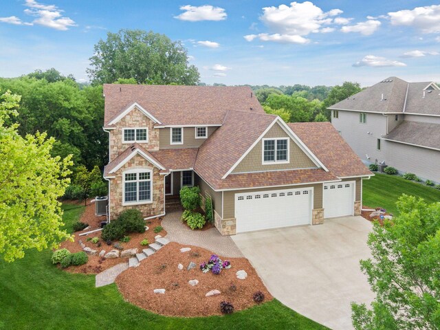 8615 Kelzer Pond Dr, Victoria, MN 55386 - view of front of house with stone siding, an attached garage, concrete driveway, a front yard, and a shingled roof