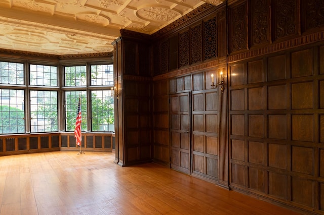 spare room with light hardwood / wood-style floors and wood walls