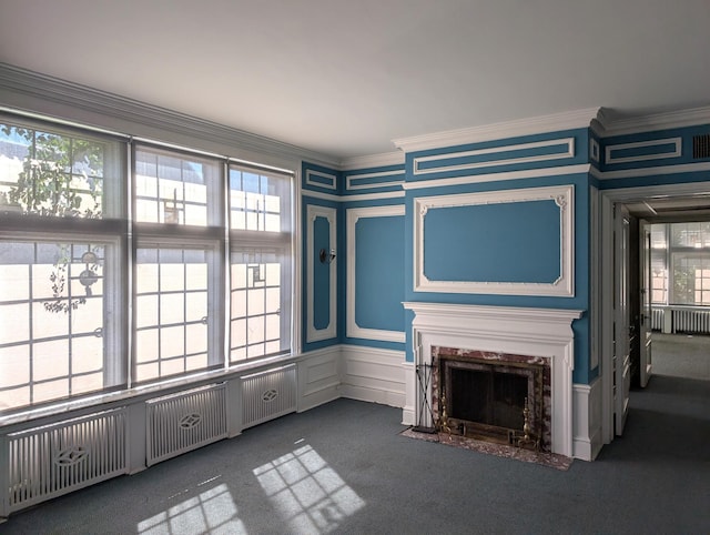 unfurnished living room with radiator heating unit, ornamental molding, and dark carpet