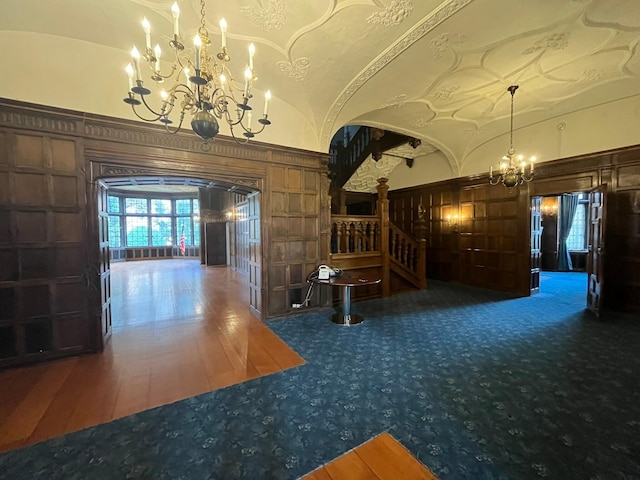 interior space with a notable chandelier, lofted ceiling, and hardwood / wood-style flooring