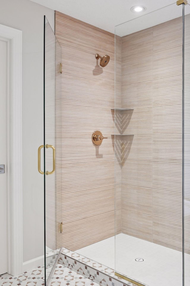 bathroom with a shower with door and tile patterned floors