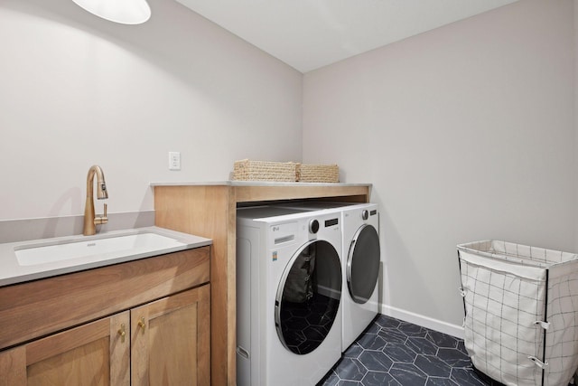 laundry area featuring cabinets, separate washer and dryer, dark tile patterned floors, and sink