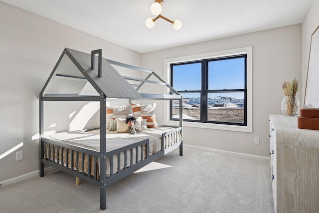 carpeted bedroom featuring a textured ceiling