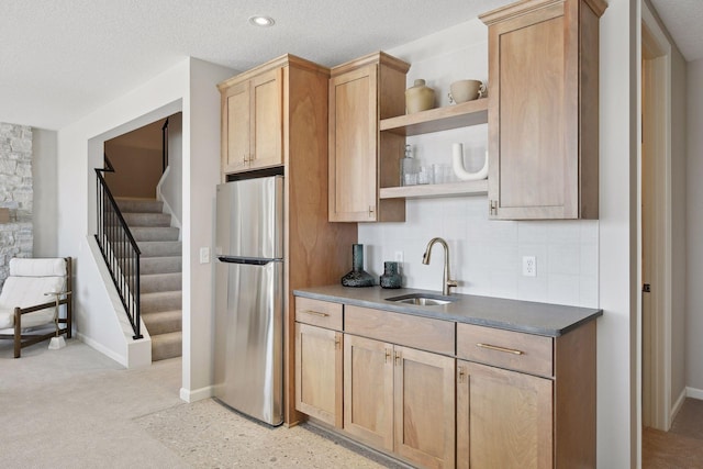 kitchen featuring sink, stainless steel fridge, light brown cabinetry, and backsplash